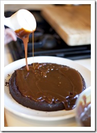 Lisa pouring the caramel on her six layer chocolate and salted caramel cake
