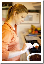 Lisa pouring the caramel on her six layer chocolate and salted caramel cake