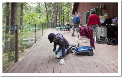 Barb putting some elbow grease into the cracks in the deck