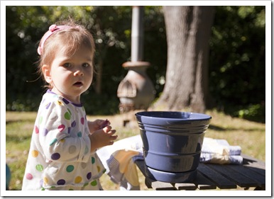 Lilia helping her two grandmothers hang up the washing