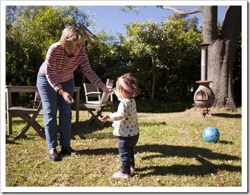 Lilia helping her two grandmothers hang up the washing