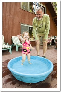Lilia enjoying her pool with Grandpa on the deck at the cabin